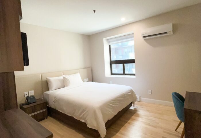 Hotel Saint-Andre's gay-friendly room. Modern interior with a bed, desk, and window. A comfortable stay for gay travelers.