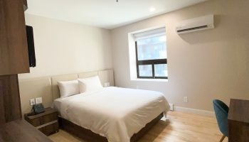 Hotel Saint-Andre's gay-friendly room. Modern interior with a bed, desk, and window. A comfortable stay for gay travelers.
