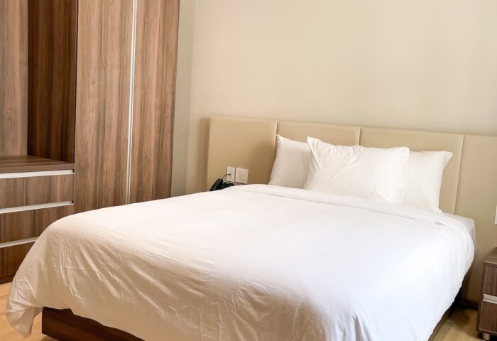 Hotel Saint-Andre gay-friendly room. Queen bed with white linens, wood floors, and wardrobe. Comfortable stay for gay travelers.