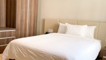 Hotel Saint-Andre gay-friendly room. Queen bed with white linens, wood floors, and wardrobe. Comfortable stay for gay travelers.