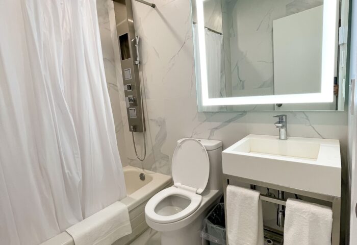 Hotel Saint-Andre bathroom. Gay-friendly hotel room with shower, toilet, sink, and illuminated mirror. Modern design, clean, and comfortable.