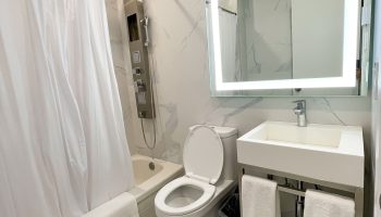 Hotel Saint-Andre bathroom. Gay-friendly hotel room with shower, toilet, sink, and illuminated mirror. Modern design, clean, and comfortable.