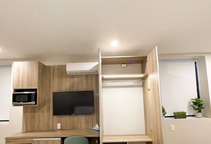 Hotel Saint-Andre gay-friendly room view. Desk, TV, wardrobe, safe, and beds are visible in this well-appointed room for gay travelers.