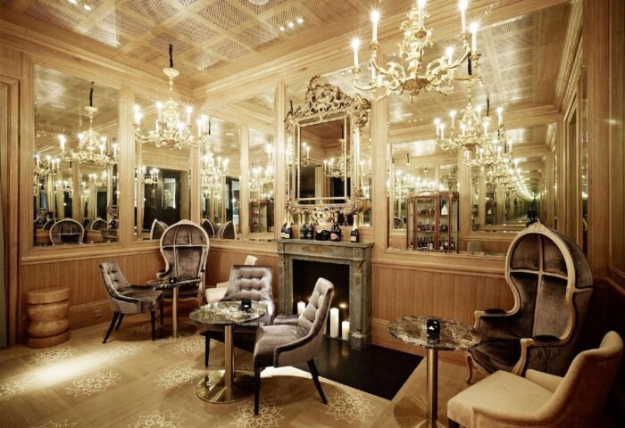 Hotel Sans Souci Wien's gay-friendly interior. A luxurious lounge area with chandeliers, mirrors, & stylish seating. Perfect for gay travelers.