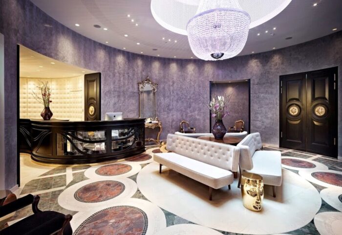 Hotel Sans Souci Wien's lobby. Gay-friendly hotel with a chandelier, sofas, and a unique floor design. Luxury travel for gay men in Vienna.