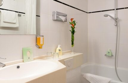 Hotel Scala's bathroom. Gay-friendly hotel room with sink, shower, and toiletries. A comfortable and clean space for gay travelers.