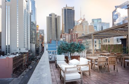 Hotel Scherman's rooftop terrace. Gay-friendly hotel with city views, lounge chairs, and tables. Perfect for gay men travel in NYC.