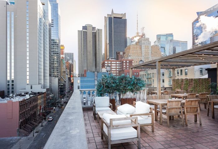 Hotel Scherman's rooftop terrace. Gay-friendly hotel with city views, lounge chairs, and tables. Perfect for gay men travel in NYC.