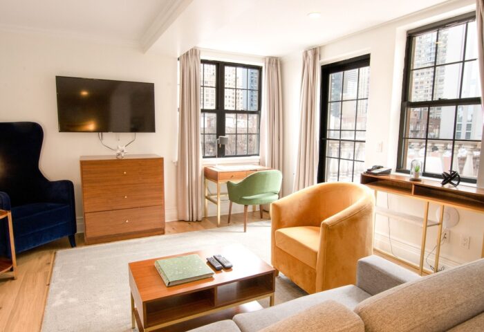 Hotel Scherman's gay-friendly room. Modern interior with armchairs, desk, and TV. A comfortable space for gay travelers to relax.