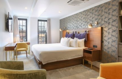 Hotel Scherman's gay-friendly room. Modern decor, king bed, desk, and armchairs. A comfortable stay for gay travelers.