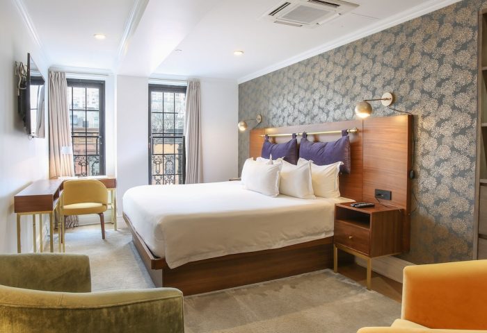 Hotel Scherman's gay-friendly room. Modern decor, king bed, desk, and armchairs. A comfortable stay for gay travelers.