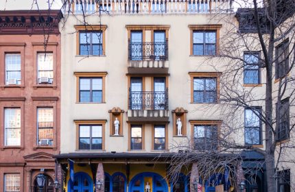 Hotel Scherman, a gay-friendly hotel. Building facade with blue and yellow accents. Balconies, statues, and architectural details.
