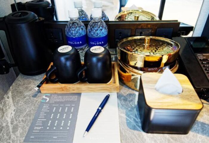 Hotel Soloha @ Chinatown room amenities: kettle, water bottles, mugs, sugar bowl, tissues, pen, and stationery. Gay-friendly hotel in Singapore.