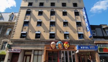 Hotel St-Denis facade, a gay-friendly hotel. The building has a vintage aesthetic with a blue HOTEL sign. A great choice for gay travel.