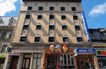 Hotel St-Denis facade, a gay-friendly hotel. The building has a vintage aesthetic with a blue HOTEL sign. A great choice for gay travel.