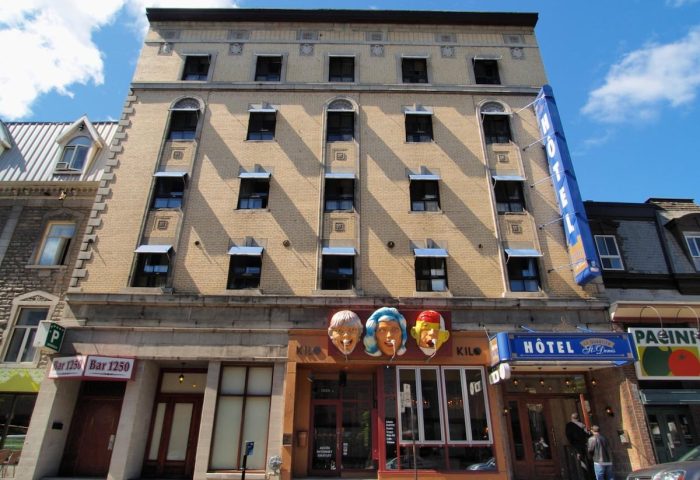 Hotel St-Denis facade, a gay-friendly hotel. The building has a vintage aesthetic with a blue HOTEL sign. A great choice for gay travel.