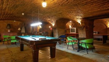 Hotel St-Denis gay-friendly hotel: Billiard room with stone walls and arched ceiling. Pool table, chairs, and tables for relaxing.