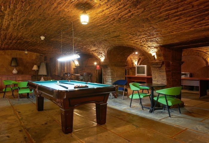 Hotel St-Denis gay-friendly hotel: Billiard room with stone walls and arched ceiling. Pool table, chairs, and tables for relaxing.