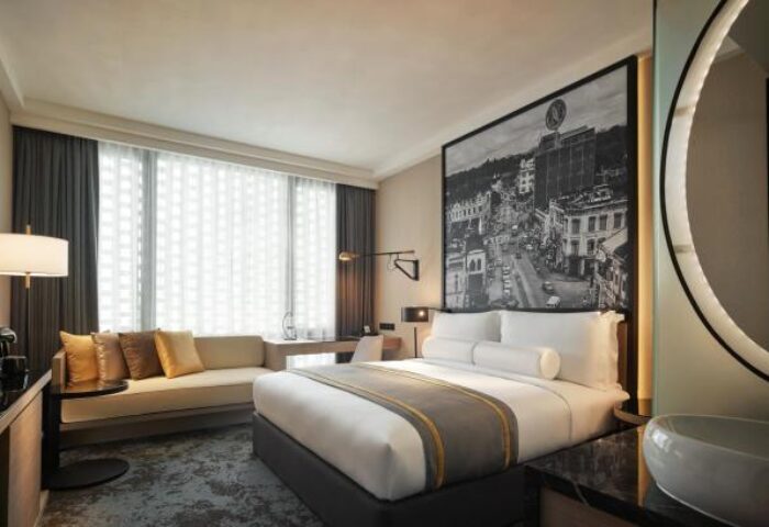 Hotel Stripes Kuala Lumpur, Autograph Collection guest room. Gay-friendly hotel with bed, sofa, desk, & city view. Modern design.