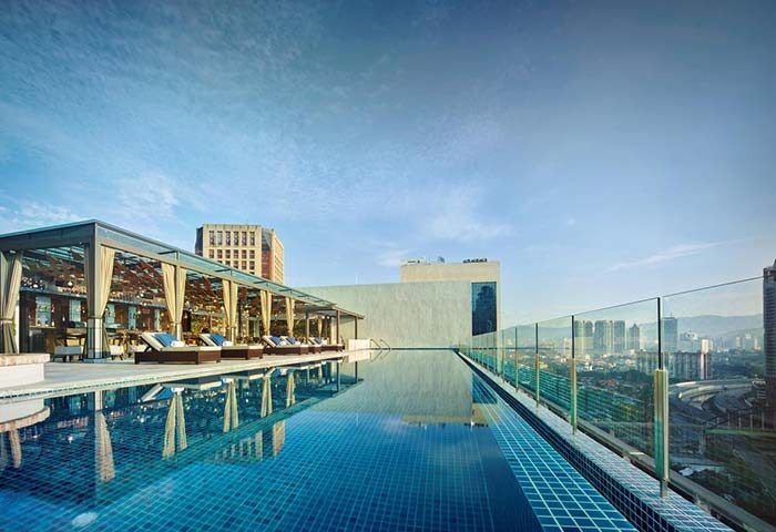 Hotel Stripes Kuala Lumpur, Autograph Collection rooftop pool. Gay-friendly hotel with city views. Lounge chairs and bar area visible.