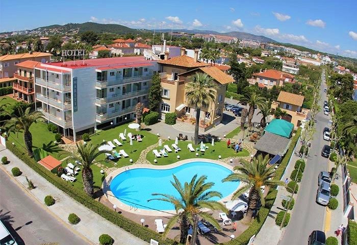 Hotel Subur Maritim aerial view. Gay-friendly, pet-friendly hotel with pool, palm trees, sun loungers, and lawn. Vilanova i la Geltrú.