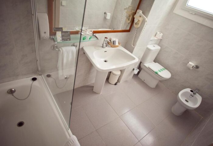 Hotel Subur Maritim bathroom. Gay-friendly hotel with a clean sink, toilet, bidet, and bathtub. Pet-friendly option for gay travel.