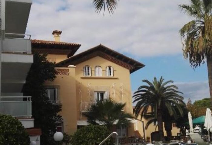 Hotel Subur Maritim garden view. Gay-friendly, pet-friendly hotel with palm trees, lawn, and building. A serene scene for gay men travelers.