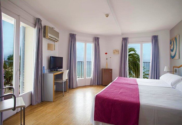 Hotel Subur Sitges gay-friendly room with balcony. Pet-friendly hotel room with twin beds, desk, TV, and ocean view.