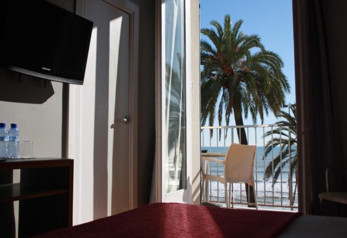 Hotel Subur Sitges gay-friendly room with balcony view. Palm trees and ocean visible. Pet-friendly hotel in Sitges, Spain.
