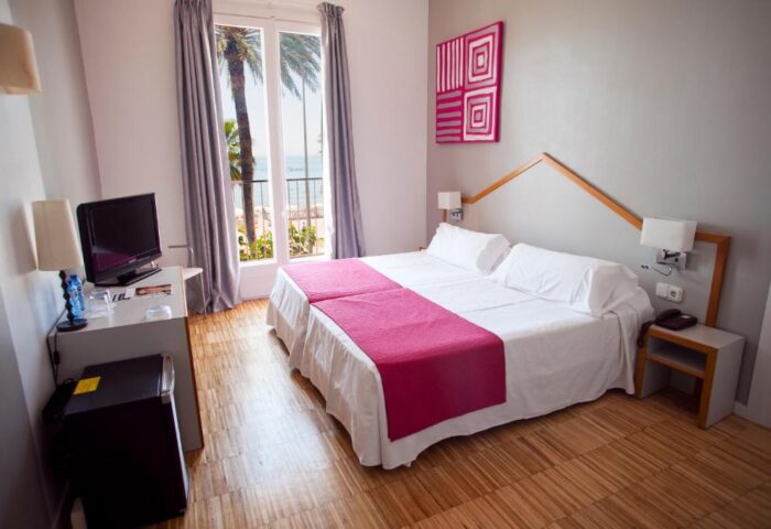 Hotel Subur Sitges gay-friendly room with twin beds, balcony view, and pet-friendly amenities. A comfortable stay for gay travelers.