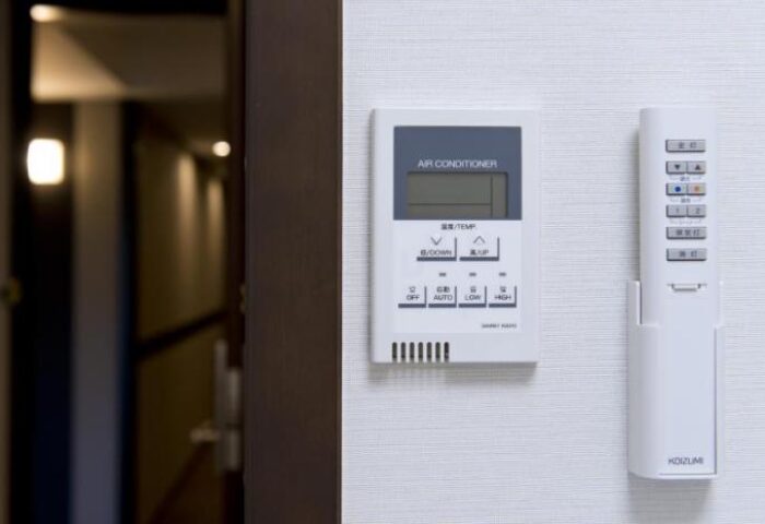 Hotel Sunlite Shinjuku gay-friendly room: Air conditioner control panel and remote. Comfortable stay for gay travelers in Shinjuku, Tokyo.