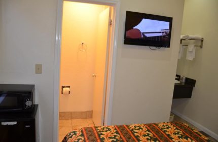 Hotel Sunrise gay-friendly room. Features include a TV, microwave, and private bathroom. Perfect for gay men's travel.