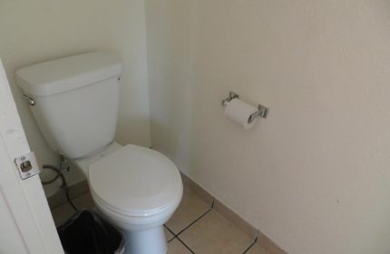 Bathroom at Gay-Friendly Hotel Sunrise. Toilet, toilet paper, and trash can. Hotel Sunrise is a great choice for gay men travelers.