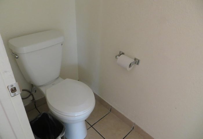 Bathroom at Gay-Friendly Hotel Sunrise. Toilet, toilet paper, and trash can. Hotel Sunrise is a great choice for gay men travelers.