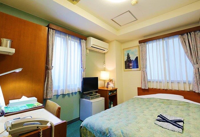Hotel Tateshina room. Gay-friendly hotel with single bed, desk, TV, air conditioning, and mini-fridge. Comfortable stay for gay travelers.