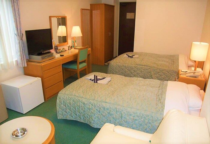 Hotel Tateshina room with twin beds, desk, & TV. Gay-friendly hotel in Japan offering comfortable accommodations for gay travelers.