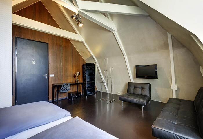 Hotel V Frederiksplein room. Gay-friendly hotel in Amsterdam with modern decor, sloped ceilings, and stylish furnishings for gay travelers.