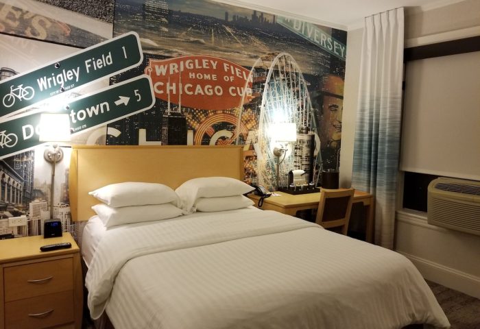 Hotel Versey Chicago Lincoln Park room. Gay-friendly hotel with a bed, desk, and Chicago-themed wall art featuring Wrigley Field.