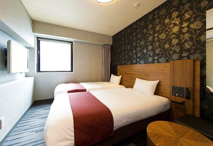 Hotel Villa Fontaine Tokyo-Shinjuku room. Twin beds, floral wallpaper, window, and TV. Gay-friendly hotel in Shinjuku, Tokyo.