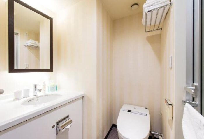 Hotel Villa Fontaine Tokyo-Shinjuku bathroom. Sink, mirror, toilet, and shower. Gay-friendly hotel in Tokyo, Japan. Ideal for gay travel.