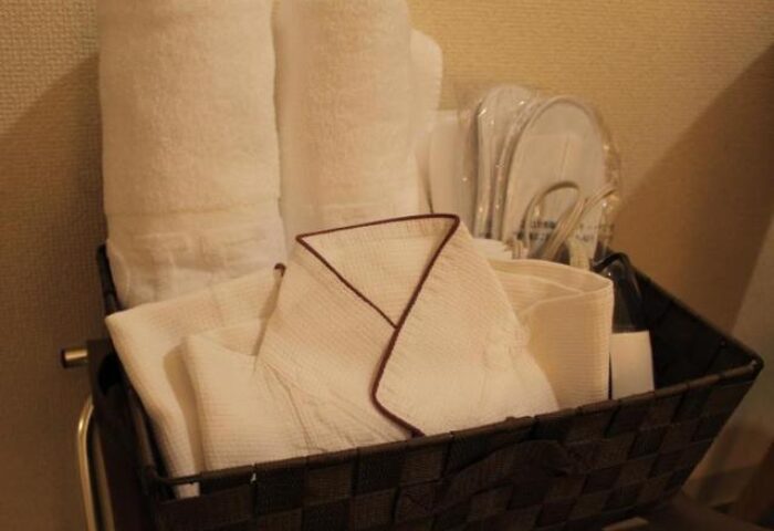 Hotel Wing International Shinjuku gay-friendly room amenities: towels, bathrobe, slippers in a basket. A comfy stay for gay travelers in Shinjuku.