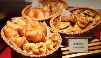 Breakfast pastries at Hotel Wing International Shinjuku, a gay-friendly hotel. Baskets of croissants and baked goods.