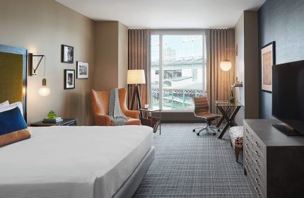 Hotel Zachary, Chicago, a Tribute Portfolio Hotel guest room. Gay-friendly hotel room with bed, chair, desk, and view of Wrigley Field.