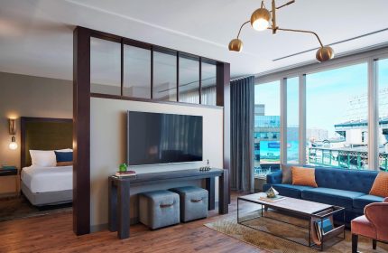 Hotel Zachary, a Tribute Portfolio Hotel, gay-friendly Chicago hotel room with a bed, TV, couch, and view of the city.