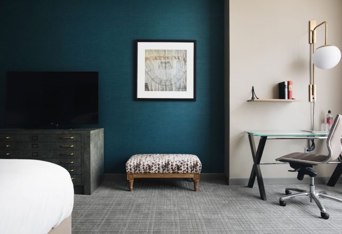 Hotel Zachary, a Tribute Portfolio Hotel, gay-friendly room. Desk, TV, and ottoman in a modern, stylish Chicago hotel room.