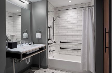 Hotel Zachary Chicago bathroom. Accessible features include grab bars, handheld shower, & roll-under sink. Gay-friendly hotel.