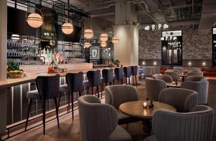 Hotel Zachary, a Tribute Portfolio Hotel in Chicago, gay-friendly. Interior view of the bar and lounge area, stylish seating and lighting.