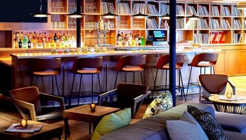 Hotel Ziggy Los Angeles bar area. Stylish, gay-friendly hotel with a bar, stools, and lounge seating. Records line the shelves. Cool design.
