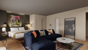 Hotel Ziggy Los Angeles gay-friendly room. A bed with white linens, a blue sectional couch, and a colorful art piece above the bed.