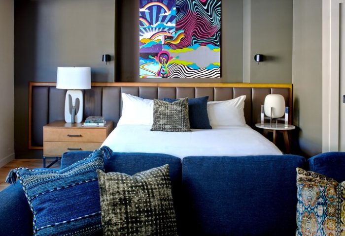 Hotel Ziggy Los Angeles gay-friendly hotel room. Bright art above bed, blue sofa with pillows. Modern design, comfortable stay.